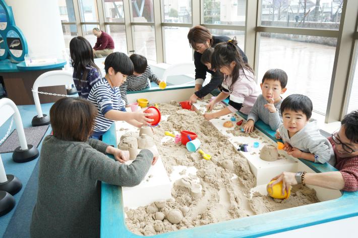 砂場で遊ぶ親子たち