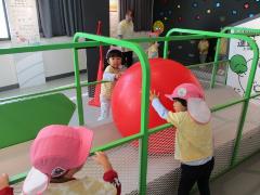 友達と大きな赤いボールを転がして遊んでいます。