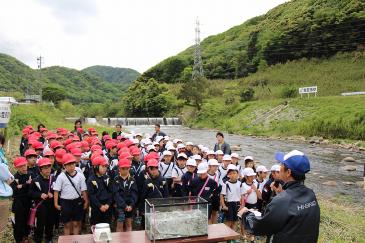 組合員から鮎の生態などについて説明を受ける児童たち