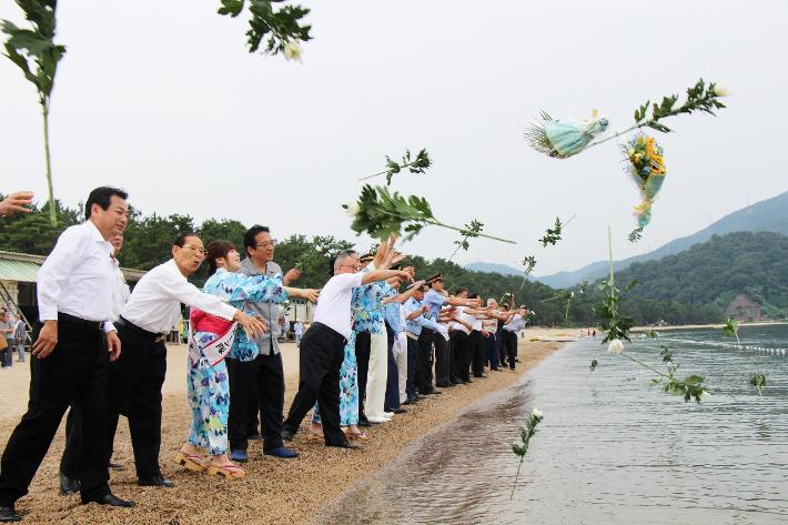 海中献花をする関係者たち