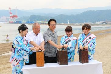 祝砲のスイッチを押す渕上市長（左から3人目）たち