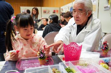 松ぼっくりツリーを作る子ども