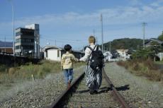 線路の上を歩く親子