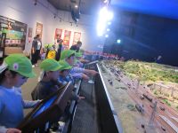 動く模型の電車を見ている子ども達