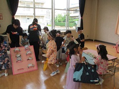 お面屋さんで、好きな色を塗って自分だけのお面を作っているよ