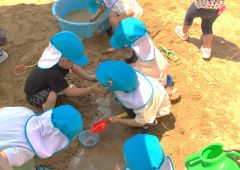園庭の砂場で遊んでいる子ども達
