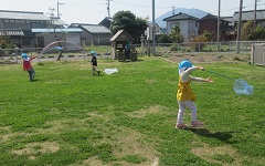 園庭で虫取りをしている