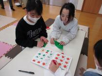 折り紙で作った作品をもってポーズをとる子ども