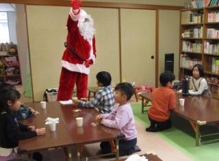 和室でサンタクロースの話を座って聞く子供たち