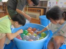 たらいの中の水風船を釣っています。