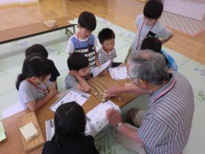 駒の進め方を教わっている様子