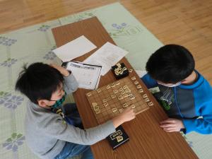 初めての将棋（解説）を見ながら駒を進める様子