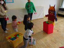 段ボールのおにに豆を投げています