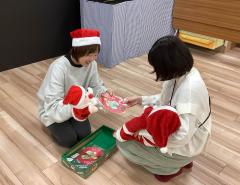 赤ちゃんを抱いた母親が職員からプレゼントをもらっている