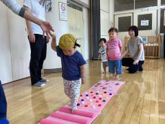 センサリーマットを進む子どもとその後ろで順番を待つ子ども2人