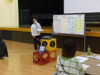 ホワイトボードの前で説明をしている