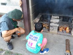 初めてかまどに火を付け、子どもが見入っている