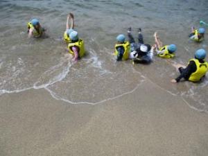 波に揺られている子ども達の画像