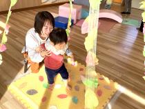 トンネルの中にある葉っぱを踏んでいる親子の画像