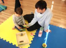 いろんなどんぐりを見ている親子の画像