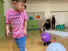 ねこ型の風船を引いている子どもの画像