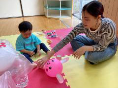 親子が風船で遊んでいる画像