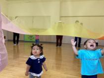 オーガンジーの下で楽しんでいる子ども2人の画像