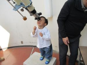 望遠鏡を覗く幼児