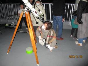 小型の望遠鏡を覗く母親