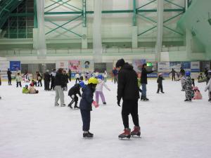 スケートを親から教えてもらう子どもの写真