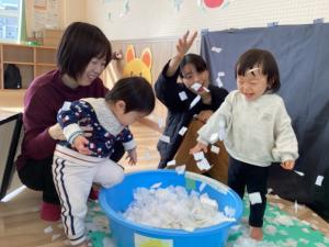 紙の素材の雪のプールではしゃぐ二組の親子の画像