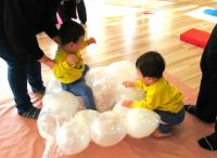 風船マットに座る男児とそこに行こうとする男児の画像