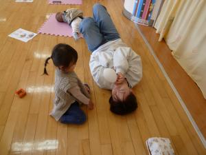 風船を膨らませているママをこどもが見守っているところです