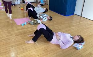 寝転がって立てた膝の間に風船を挟んでストレッチをしているところです