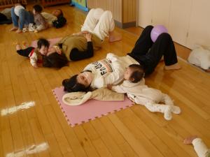 寝転がっているママの側で嬉しそうな表情のこどもです