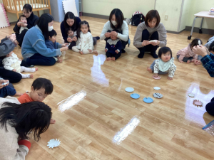 親子で紙皿のコマを作ったり回したりしています