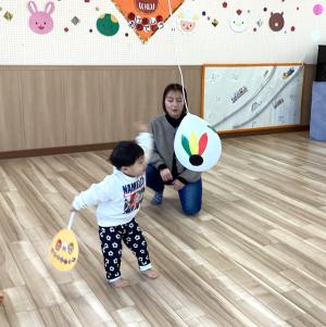 うちわの羽子板で風船を当てる男児の画像