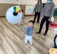 はたいて向こうへ飛んでいく風船指さす男児の画像