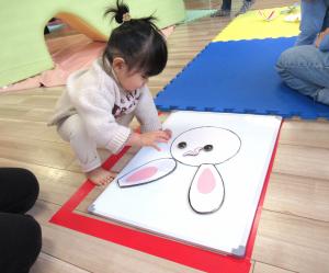 うさぎの福笑いをしている女児の画像