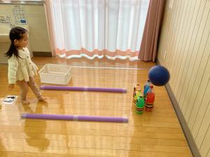 鬼のボーリングめがけてボールを投げています