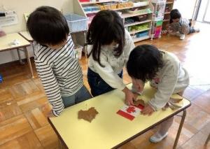 カナダの国旗とカエデの葉っぱを見比べています