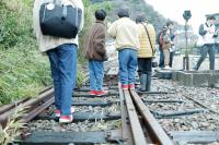 線路上を歩く家族の画像