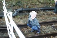 線路上でしゃがんでいる子どもの画像