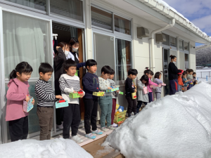 外に向かって豆まきをしています