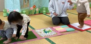 0歳児がセンサリーマットで感触を楽しみながら歩いています