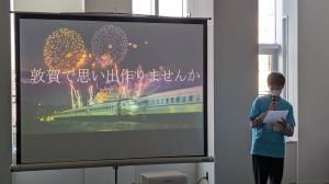 「敦賀で思い出作りませんか」の文字が映し出されたモニターの前で話す参加者の画像