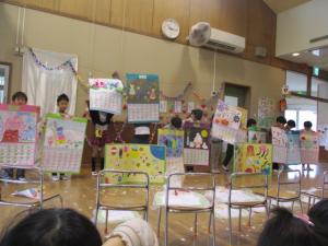 ざりがに組が作ったカレンダーとついたてのプレゼントを見せている写真