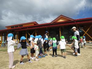 戸外でわらべ歌遊びをしている写真