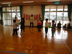 お雛様達の前で菱餅を運んでいます