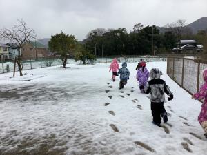 雪の中を歩く子ども達